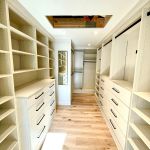 Arctic walk-in closet with flat drawer fronts, black hardware, full backing, crown to ceiling, full length mirror.