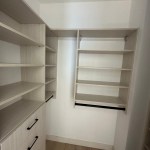 Arctic walk-in closet with flat drawer fronts and black hardware. Carbondale, CO