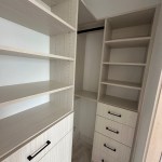 Arctic walk-in closet with flat drawer fronts and black hardware. Carbondale, CO